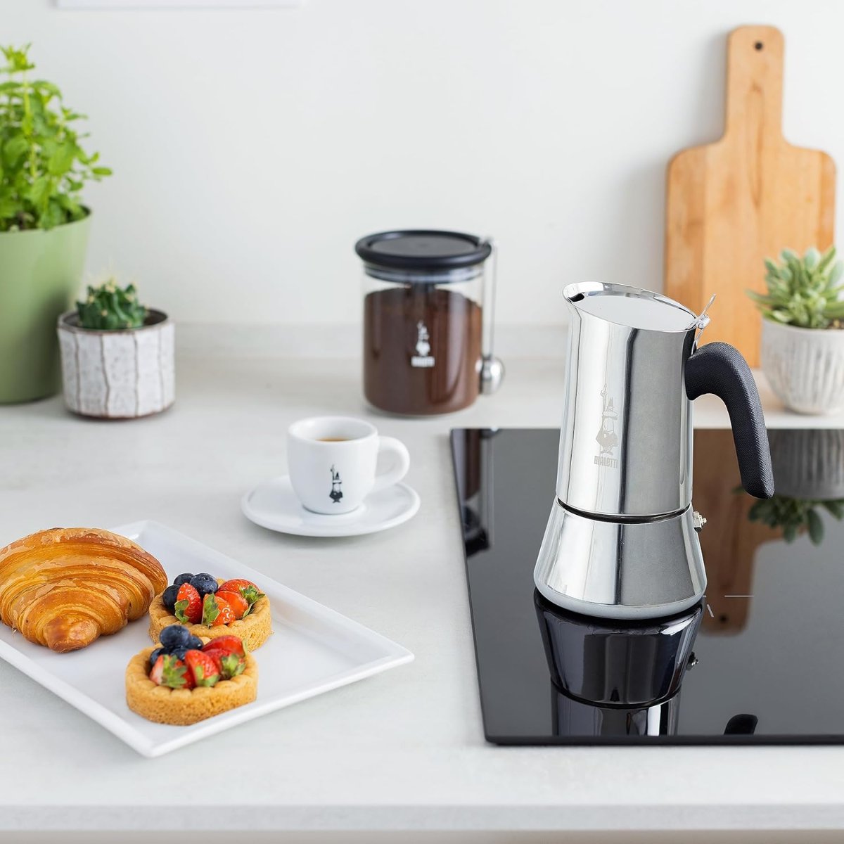 Tasse à expresso remplie à côté de la cafetière Bialetti Venus Induction sur une plaque à induction